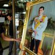 A Thai man looks at a portrait photo of Crown Prince Maha Vajiralongkorn at a shop along a street in Bangkok
