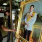 A Thai man looks at a portrait photo of Crown Prince Maha Vajiralongkorn at a shop along a street in Bangkok