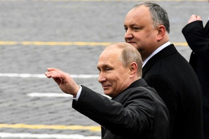 Russian President Vladimir Putin (L) and his Moldovan counterpart Igor Dodon walk on Red Square after the Victory Day military parade in Moscow on May 9, 2017