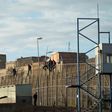 African immigrants sit on a border fence separating Morocco from the Spanish enclave of Melilla in 2014
