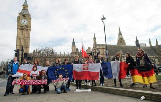Demonstrators with national flags including that of Poland (centre) pose in front of "Big Ben" in London during a "Flag Mob" rally on February 20, 2017 in support of migrants in the UK