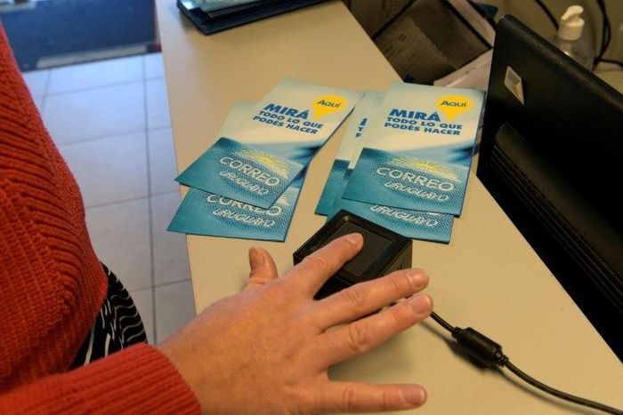 A woman registers as a marijuana buyer at a state post office in Montevideo on May 2, 2017