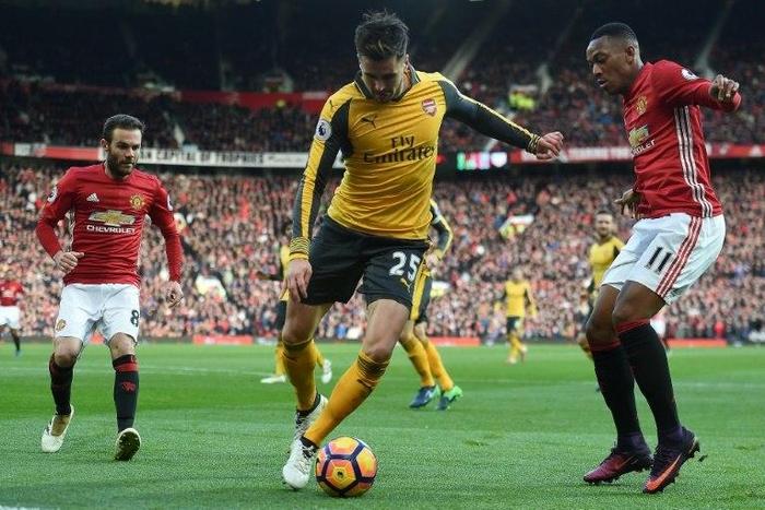 Arsenal's defender Carl Jenkinson (C) vies with Manchester United's striker Anthony Martial (R) and midfielder Juan Mata during the English Premier League football match November 19, 2016