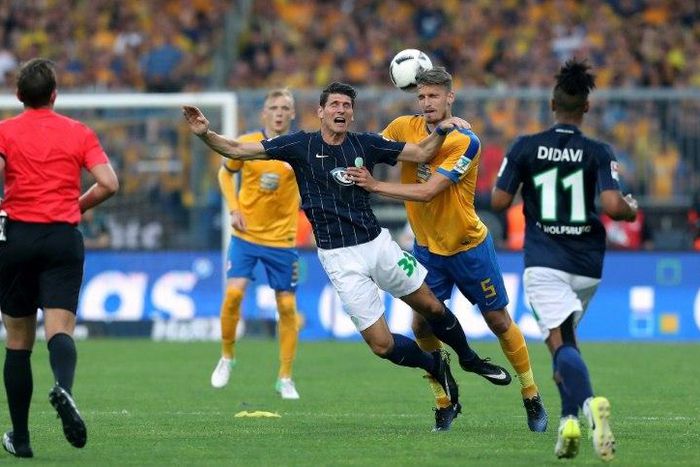 Wolfsburg's forward Mario Gomez (C), Braunschweig's Norwegian defender Gustav Valsvik (2ndR) vie during the Bundesliga Playoff second leg match between Eintracht Braunschweig and VfL Wolfsburg at Eintracht Stadium on May 29, 2017