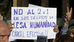 A demonstrator holds a sign reading in Spanish "No two for one for crimes against humanity; full jail-time!" during the Madres de Plaza de Mayo human rights group's weekly demonstration at the Plaza de Mayo square in Buenos Aires on May 4, 2017