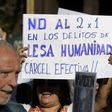A demonstrator holds a sign reading in Spanish "No two for one for crimes against humanity; full jail-time!" during the Madres de Plaza de Mayo human rights group's weekly demonstration at the Plaza de Mayo square in Buenos Aires on May 4, 2017