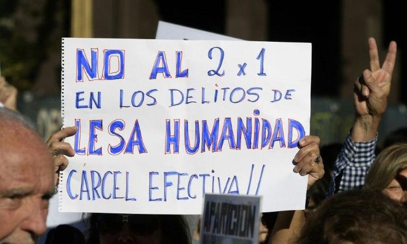 A demonstrator holds a sign reading in Spanish "No two for one for crimes against humanity; full jail-time!" during the Madres de Plaza de Mayo human rights group's weekly demonstration at the Plaza de Mayo square in Buenos Aires on May 4, 2017