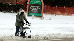 A person with a walker crosses Canfield Avenue in Detroit, Michigan