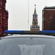 A group of men pictured through a police car window in central Moscow, with the Kremlin's Spasskaya (Saviour) Tower seen in the background, on March 1, 2017