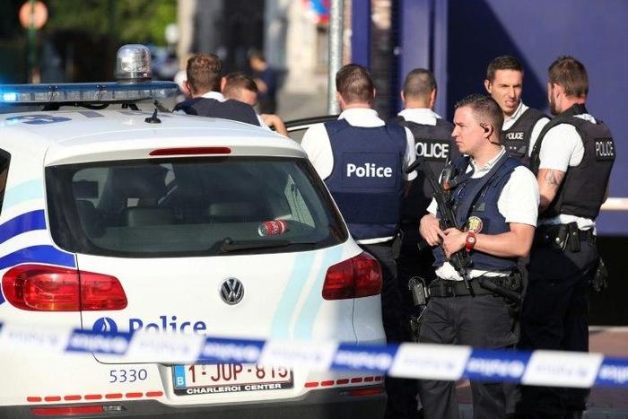 Police stand as they secure the area around a police building in the southern Belgian city of Charleroi following a machete attack on August 6, 2016