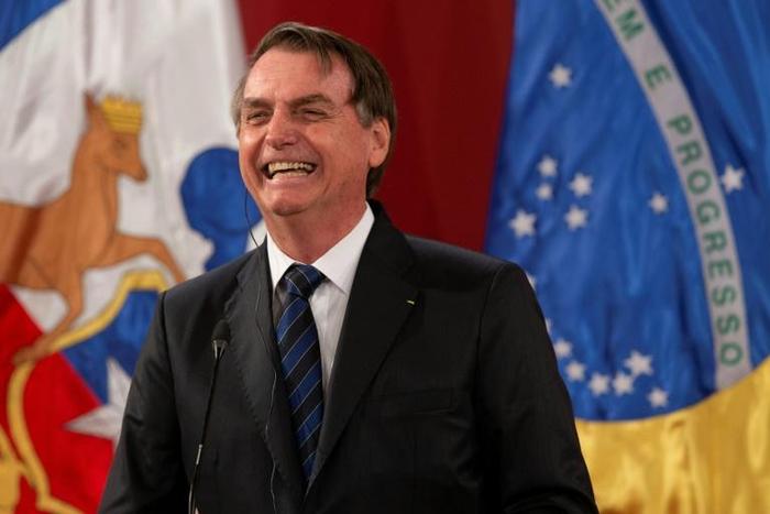 Brazil's President Jair Bolsonaro laughs during a joint press conference with Chilean President Sebastian Pinera (out frame) at La Moneda Presidential Palace in Santiago, on March 23, 2019.