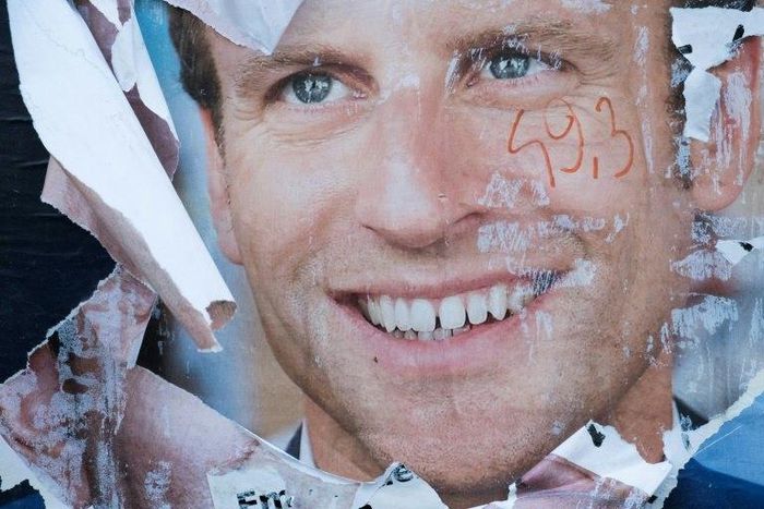 A vandalised electoral campaign poster of Emmanuel Macron in the run-up to the presidential election