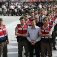 The suspects in the trial over the attempted coup in Turkey last year are paraded into the courtroom by heavily armed security forces