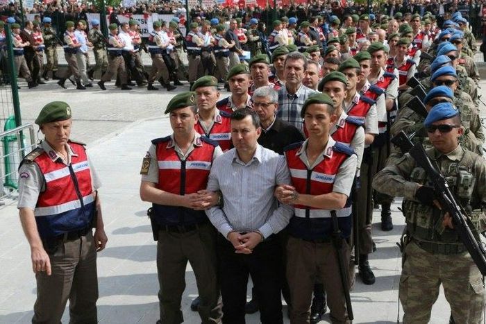 The suspects in the trial over the attempted coup in Turkey last year are paraded into the courtroom by heavily armed security forces