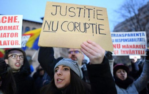 A woman holds a placard reading "Justice not Corruption" during a protest against government corruption in Bucharest January 22, 2017