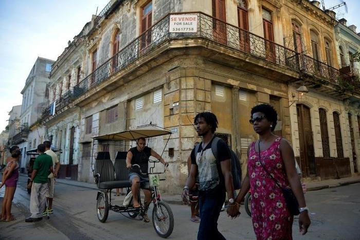 People walk past a building for sale in Havana, Cuba, as US Secretary of State Mike Pompeo warned foreign businesses to steer clear of formerly private properties seized by the island nation