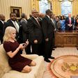 US President Donald Trump's senior advisor Kellyanne Conway (L) checks her phone after taking a photo as Donald Trump hosts leaders of historically black universities and colleges in the Oval Office on February 27, 2017