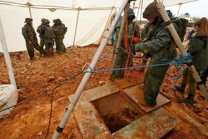 A picture taken on December 19, 2018 during a guided tour by Israel's army shows a soldier operating a pulley near a hole dug by the army to intercept a suspected Hezbollah cross-border tunnel between Lebanon and Israel