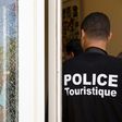 A Tunisian police officer stands guard near a bullet hole at the the Riu Imperial Marhaba Hotel after an attack that left 38 people dead on June 25, 2015