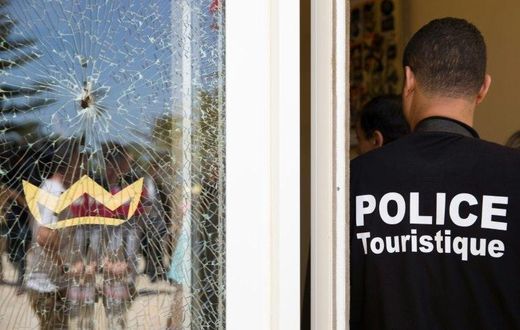 A Tunisian police officer stands guard near a bullet hole at the the Riu Imperial Marhaba Hotel after an attack that left 38 people dead on June 25, 2015
