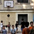 Children play in the courtyard of an abandoned school used to host Syrian and Afghan refugees in Athens on July 1, 2016