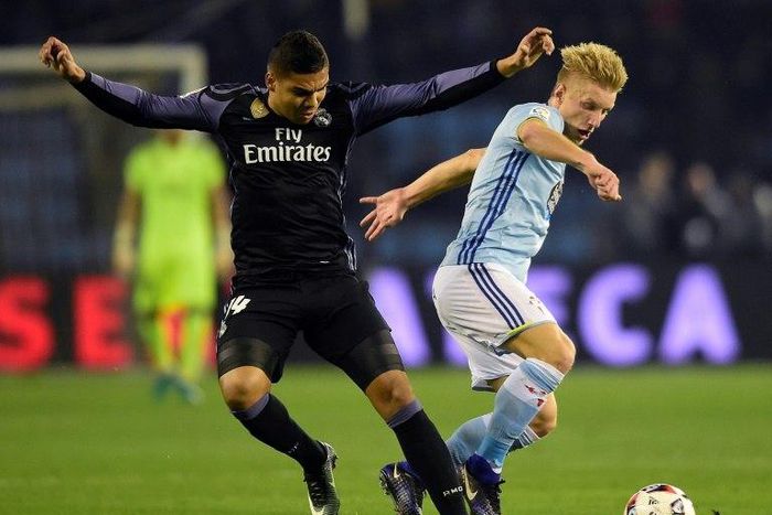 Real Madrid's Casemiro (L) fights for the ball with Celta Vigo's Daniel Wass during their Spanish Copa del Rey (King's Cup) quarter-final second leg match, in Vigo, on January 25, 2017