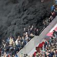 Thick black smoke forces a five-minute interruption of play during the crunch PSV Eindhoven tie with Ajax at the Philips Stadion