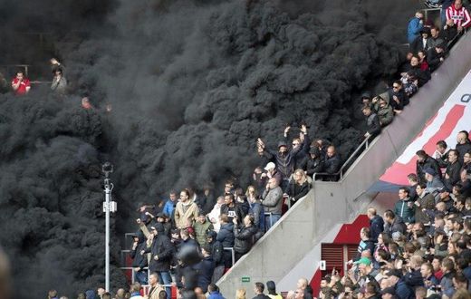 Thick black smoke forces a five-minute interruption of play during the crunch PSV Eindhoven tie with Ajax at the Philips Stadion