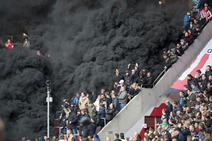 Thick black smoke forces a five-minute interruption of play during the crunch PSV Eindhoven tie with Ajax at the Philips Stadion