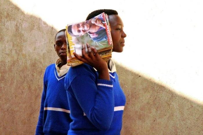 A refugee student holds magazines at the Kiziba camp in western Rwanda