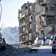 A UN convoy drives past damaged buildings in the eastern neighbourhoods of Syria's Aleppo on February 1, 2017
