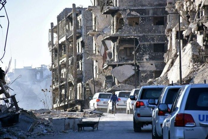 A UN convoy drives past damaged buildings in the eastern neighbourhoods of Syria's Aleppo on February 1, 2017