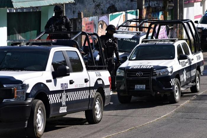 Police stationed outside the house in Veracruz where 13 people were killed in a shooting on Friday