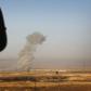 Smoke billows on the front line as an Iraqi Kurdish peshmerga fighter looks on from a position east of the city of Mosul