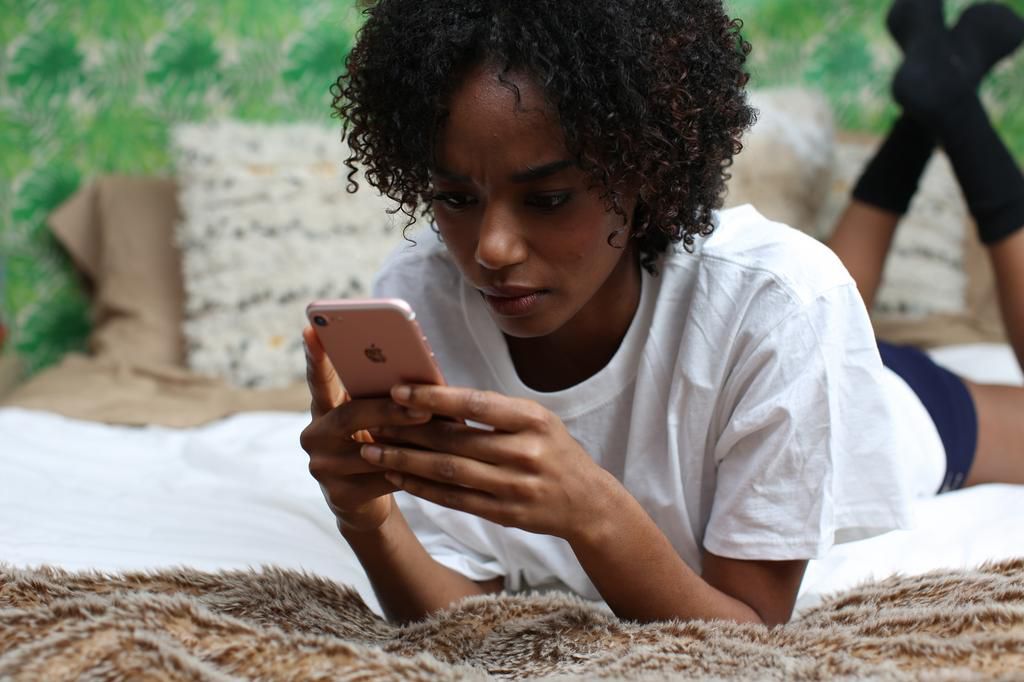 Woman texting in bed