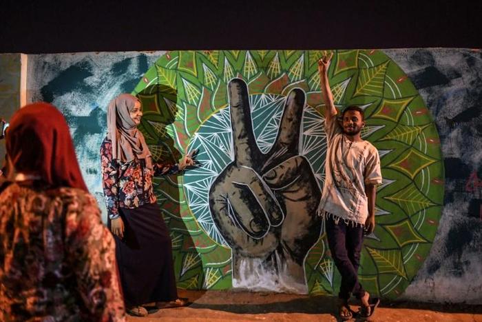 Once-grey walls near the military headquarters are painted with large clenched fists and victory signs symbolic of the popular uprising