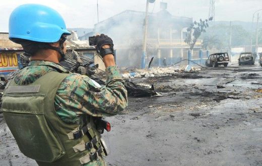 A UN peacekeeper inspects the aftermath of a 2013 blaze that swept through a market in Port-au-Prince