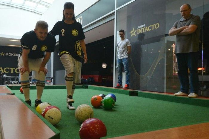 Footballpool is a combination of football and pool; the sport uses inflatable footballs - white, solids and stripes like in pool - and a playground with six holes, proportionally larger than the regular pool table