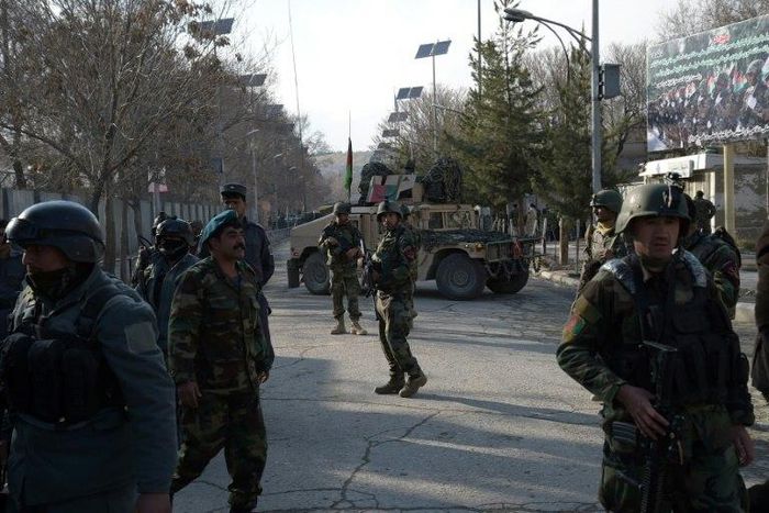 Afghan security personnel stand guard in front of the main gate of a military hospital in Kabul on March 8, 2017, after a deadly attack