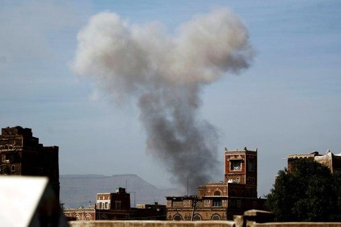 Smoke billows behind a building following a reported air strike by the Saudi-led coalition in the Yemeni capital Sanaa on January 22, 2017