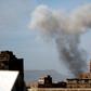 Smoke billows behind a building following a reported air strike by the Saudi-led coalition in the Yemeni capital Sanaa on January 22, 2017