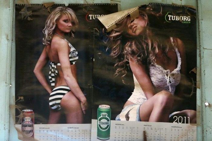 Pages of a calendar bearing images of scantily clad women attached to the wall of an alcohol shop in the Iraqi town of Bashiqa, near Mosul