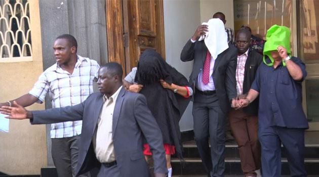 Detectives escort suspects arrested over fake Sh2 billion