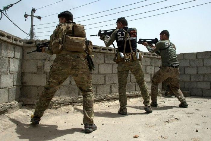 Iraqi forces fire from a position on the rooftop of a building in Mosul's northwestern al-Haramat neighbourhood on May 11, 2017 during their ongoing offensive to retake the area from Islamic State (IS) group fighters