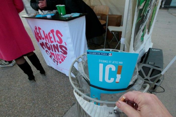 A man puts out his cigarette at the entrance of the Gare de Lyon railway station in Paris