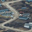 Aerial view of a residential neighborhood in Fort McMurray, Canada, where some homes have been rebuilt but many have not, one year after a massive forest fire
