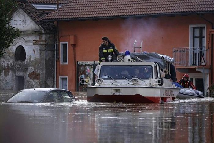 People sit in a boat of the Italian fire fighters as they help them to evacuate from their home in Moncalieri, near Turin, on November 25, 2016 because of the floods due to heavy rains