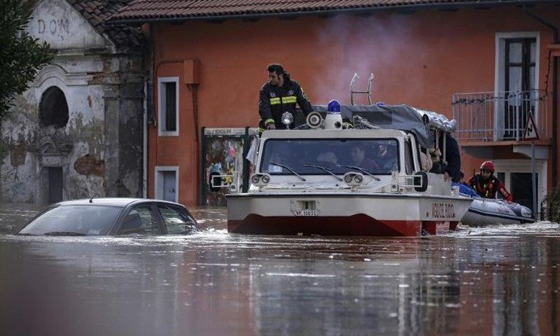 People sit in a boat of the Italian fire fighters as they help them to evacuate from their home in Moncalieri, near Turin, on November 25, 2016 because of the floods due to heavy rains