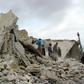 Civilians check destroyed buildings in the Syrian village of Kfar Jales, on the outskirts of Idlib, following air strikes by Syrian and Russian warplanes