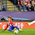 Atletico Madrid forward Antoine Griezmann (L) curls a cross in past Leicester City defender Christian Fuchs during the Champions League quarter-final first leg at the Vicente Calderon stadium in Madrid on April 12, 2017
